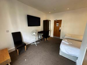 a hotel room with a bed and a desk and a tv at Somerset Hotel Baker Street London in London