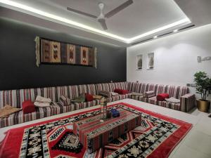 a living room with a couch and a rug at G R A N D C H A L E T in Salalah