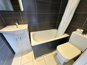 a bathroom with a sink and a tub and a toilet at Somerset Hotel Baker Street London in London