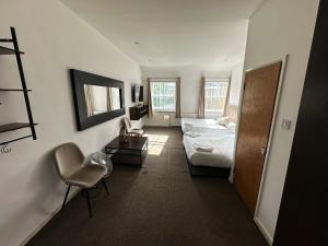 a bedroom with a bed and a chair in a room at Somerset Hotel Baker Street London in London