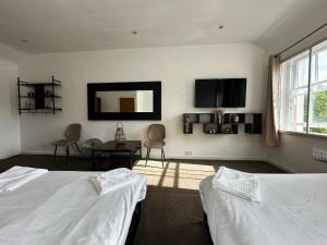 a bedroom with two beds and a mirror on the wall at Somerset Hotel Baker Street London in London