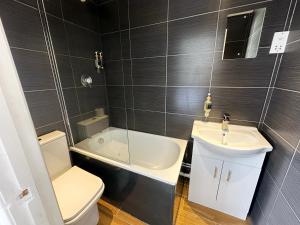 a bathroom with a toilet and a sink and a tub at Somerset Hotel Baker Street London in London