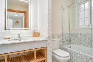 a bathroom with a sink and a toilet and a tub at Balcón del Mar in La Herradura +24 photos