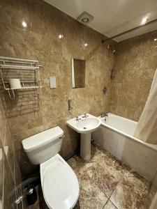 a bathroom with a toilet and a sink and a tub at Somerset Hotel Baker Street London in London +37 photos