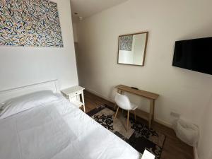 a bedroom with a bed and a desk and a television at Somerset Hotel Baker Street London in London