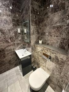 a bathroom with a toilet and a sink at Somerset Hotel Baker Street London in London