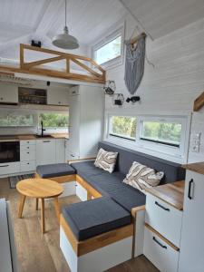 a kitchen and living room of a tiny house at Tajnikowo Sekretny Tiny House Wasabi in Łubiana