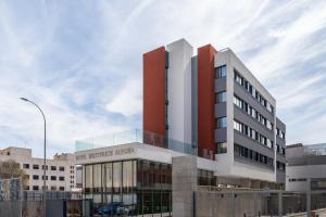 a large building with a red and white facade at Hotel BESTPRICE Alegría in Madrid