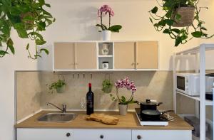 a kitchen counter with a sink and a bottle of wine at Sermina Apartment V in La Maddalena