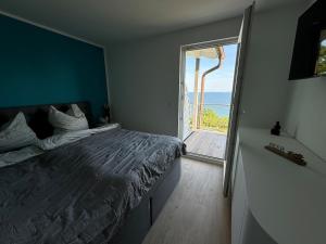 una camera da letto con un letto grande e una grande finestra di Apt MehrMeer DG mit Sauna Pool Fitness a Sassnitz