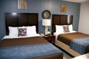 SpencerにあるSouth T Motelのベッド2台と鏡が備わるホテルルームです。