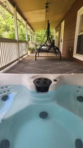 a hot tub on the porch of a house at Red River Gorge Farmhouse 50 Acres in Stanton