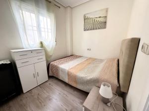mała sypialnia z łóżkiem i oknem w obiekcie Mar Menor w mieście Torrevieja