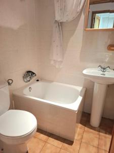 a bathroom with a toilet and a tub and a sink at Isard Apartment in Pla de l'Ermita +23 photos