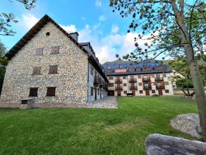 an exterior view of a building with a grass yard at Isard Apartment in Pla de l'Ermita