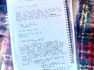 a notebook with handwriting on it next to some glitter at Eco Crofter's Wagon by the Sea - Off Grid Experience - No electricity - As seen soon on Netflix in Oldshoremore