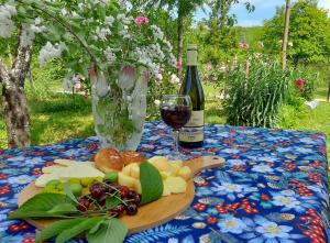 Ein Teller mit Obst und ein Glas Wein auf einem Tisch in der Unterkunft Lellia in Martvili