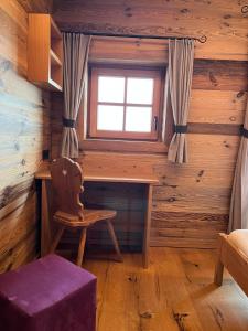 Habitación con escritorio, ventana y silla. en Chalet Hüttenzauber, en Saalbach Hinterglemm