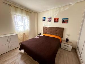 sypialnia z dużym łóżkiem i pomarańczowym kocem w obiekcie Mar Menor w mieście Torrevieja
