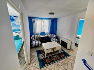 Una sala de estar con paredes azules y una mesa. en Vila Calut de mare Jurilovca, en Jurilovca