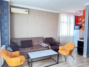 a living room with a couch and two chairs at Apartament on Rustaveli in Batumi