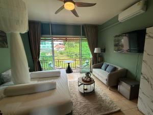 a living room with a couch and a ceiling fan at Alura Boutique in Kata Beach