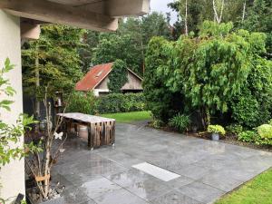 ホイエルスヴェルダにあるCharming Family Retreat in Hoyerswerda, Germanyの庭のパティオ(木製テーブル付)