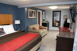 ein Hotelzimmer mit einem Bett und einem Wohnzimmer in der Unterkunft South T Motel in Spencer