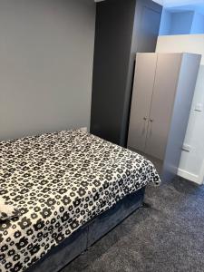 a bedroom with a bed with a black and white blanket at Royal Apartments SouthBank 1 in South Bank