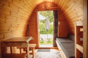 una stanza con panchina e finestra in una cabina di Camping Le Pommier Rustique a Yvoir