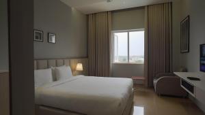 拉杰果德Pride Resort, Rajkot的一间有床和窗户的酒店房间