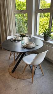 ein schwarzer Tisch mit zwei weißen Stühlen und ein Tisch mit Gläsern in der Unterkunft Village Retreat in Hillsborough