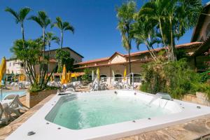a pool with a hot tub in front of a house at Hotel Fazenda Fonte Colina Verde in São Pedro