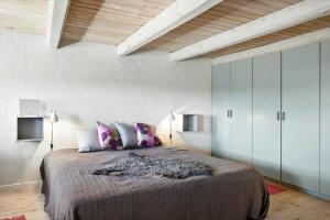 a bedroom with a large bed and white cabinets at Restaureret Bondehus Nær Kattegat Med Stor Have in Hadsund