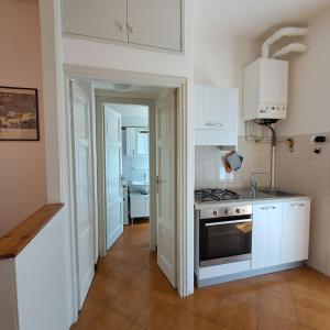 a kitchen with white cabinets and a stove at Appartamento Angelina in Stresa