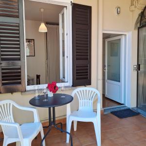 a table and two chairs and a table with flowers on it at Appartamento Angelina in Stresa