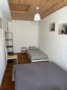 a bedroom with two beds and a chair in it at Charmante maison de village 30 min Puy DuFou in Bazoges-en-Pareds