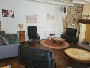 a living room with a couch and a table at Charmante maison de village 30 min Puy DuFou in Bazoges-en-Pareds