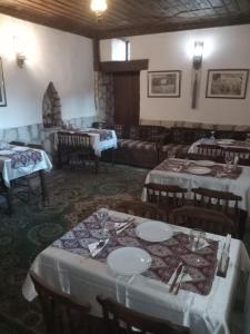a dining room with tables and chairs with white tablecloths at Han Safranbolu in Safranbolu