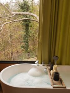 a bath tub with a window in a bathroom at Gonio Limoncello in Gonio +33 photos