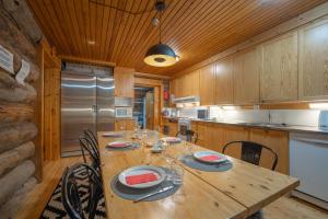 a kitchen with a wooden table with wine glasses on it at Kuukkeli Log Houses Aurora Resort in Saariselka +30 photos