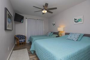 a bedroom with two beds and a ceiling fan at Island Time- Wonderful Private Beachfront Home - Beautiful!!! in Panama City Beach