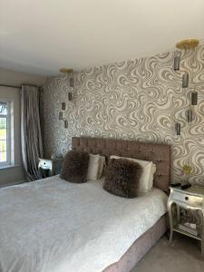 a bedroom with a bed with a patterned wall at Brig o Doon 2 in Ayr