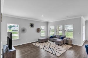 a living room with a couch and a tv at Charming 4BR Ranch-Style Home - Corner Lot home in Harvest +27 photos