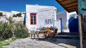 a table and chairs in front of a white building at Clive and Bifi's house in Lachania