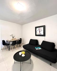 a living room with a black couch and a table at Farm House Near Of Merhia Beach In Mykonos in Merchia Beach