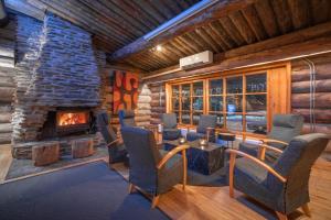 a living room with a fireplace in a log cabin at Kuukkeli Log Houses Aurora Resort in Saariselka
