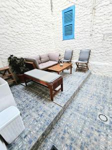 a patio with a couch and two chairs at Perla del Sud - Guest House in Lampedusa