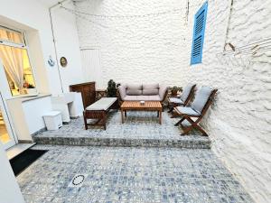 a patio with a couch and chairs and a table at Perla del Sud - Guest House in Lampedusa +13 photos