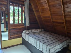 Cama ou camas em um quarto em Chalé dos Campos